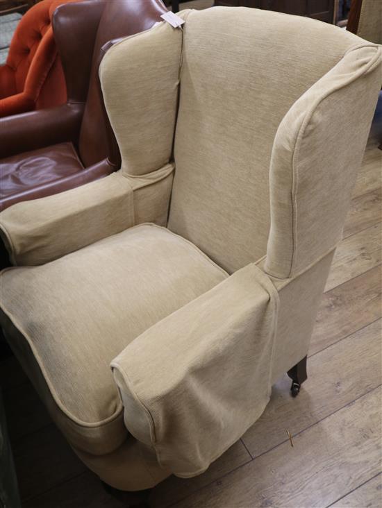 An upholstered wing back armchair